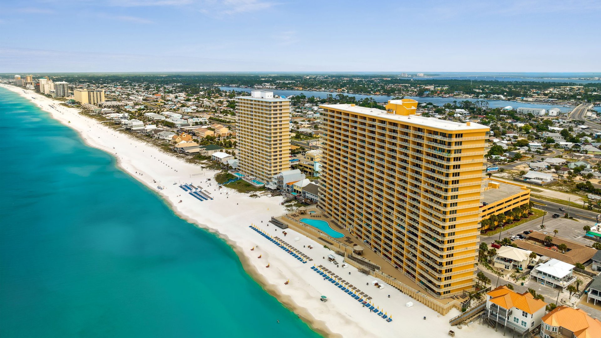 Stunning beachfront property towers overlook pristine white sand beaches and turquoise Gulf waters in this vibrant coastal destination.