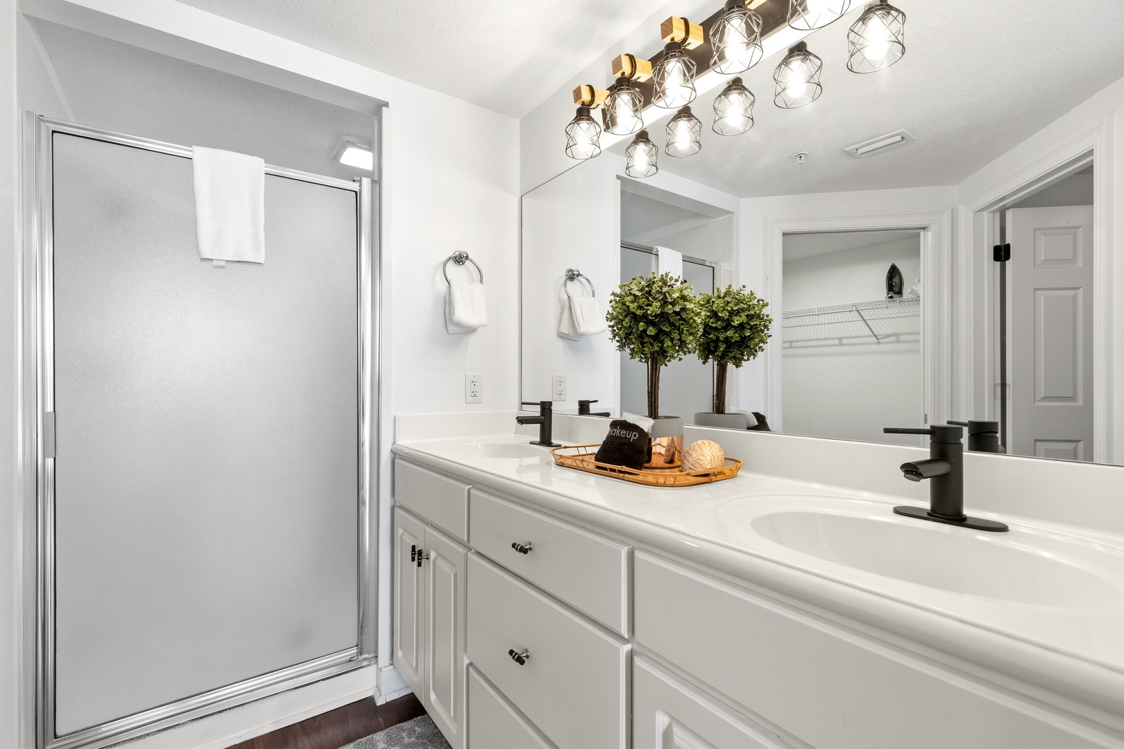 Freshen up in this elegant bathroom with dual sinks, stylish lighting, and thoughtful touches like fresh greenery that make you feel at home.