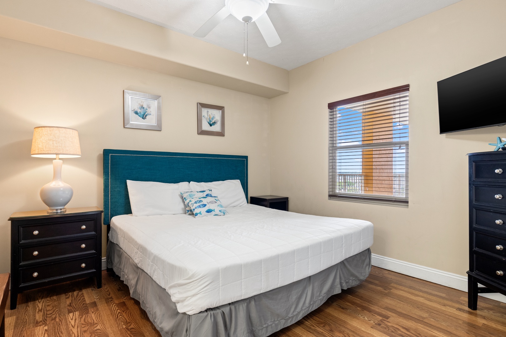 Your peaceful retreat features a plush bed with crisp linens, coastal-inspired décor, and a ceiling fan to keep you comfortable, plus a mounted TV for your downtime.