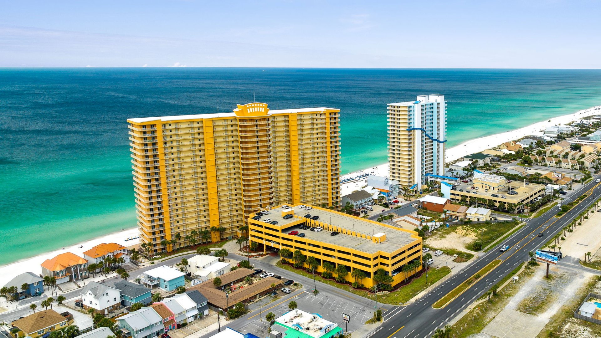 Beachfront resort towers rise along pristine emerald waters and white sand beaches in this coastal destination.