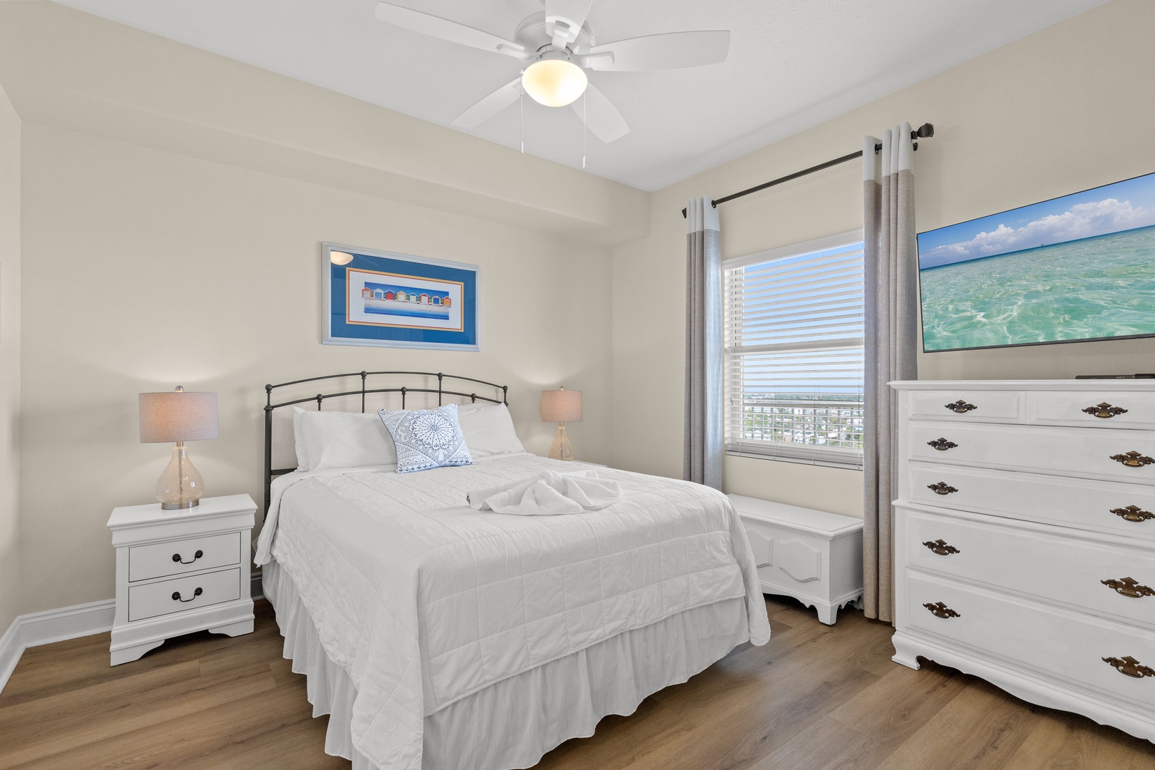 Your bright, peaceful bedroom features a comfy queen bed with crisp linens, gentle ceiling fan, and plenty of storage space.