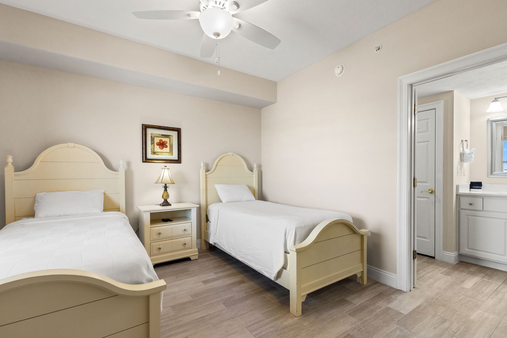 Your comfortable twin bedroom features two beds with crisp linens, gentle ceiling fan, and convenient kitchenette access for late-night snacks.