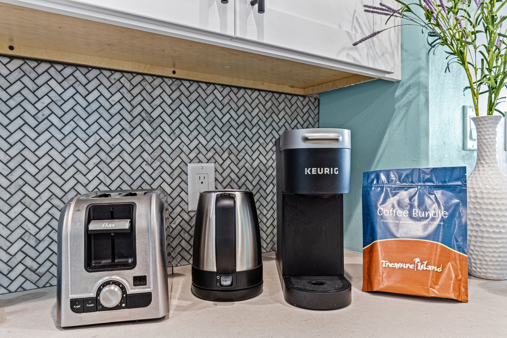 Your mornings start easy with a fresh brew from the Keurig and perfectly toasted breakfast, all set against a stylish herringbone backsplash.