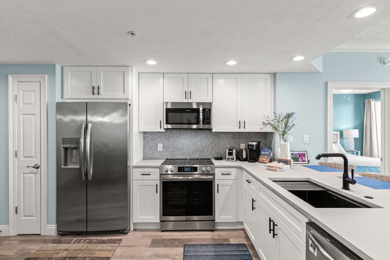 Your fully equipped kitchen features stainless steel appliances, white cabinetry, and stylish backsplash—perfect for preparing meals with ease during your stay.