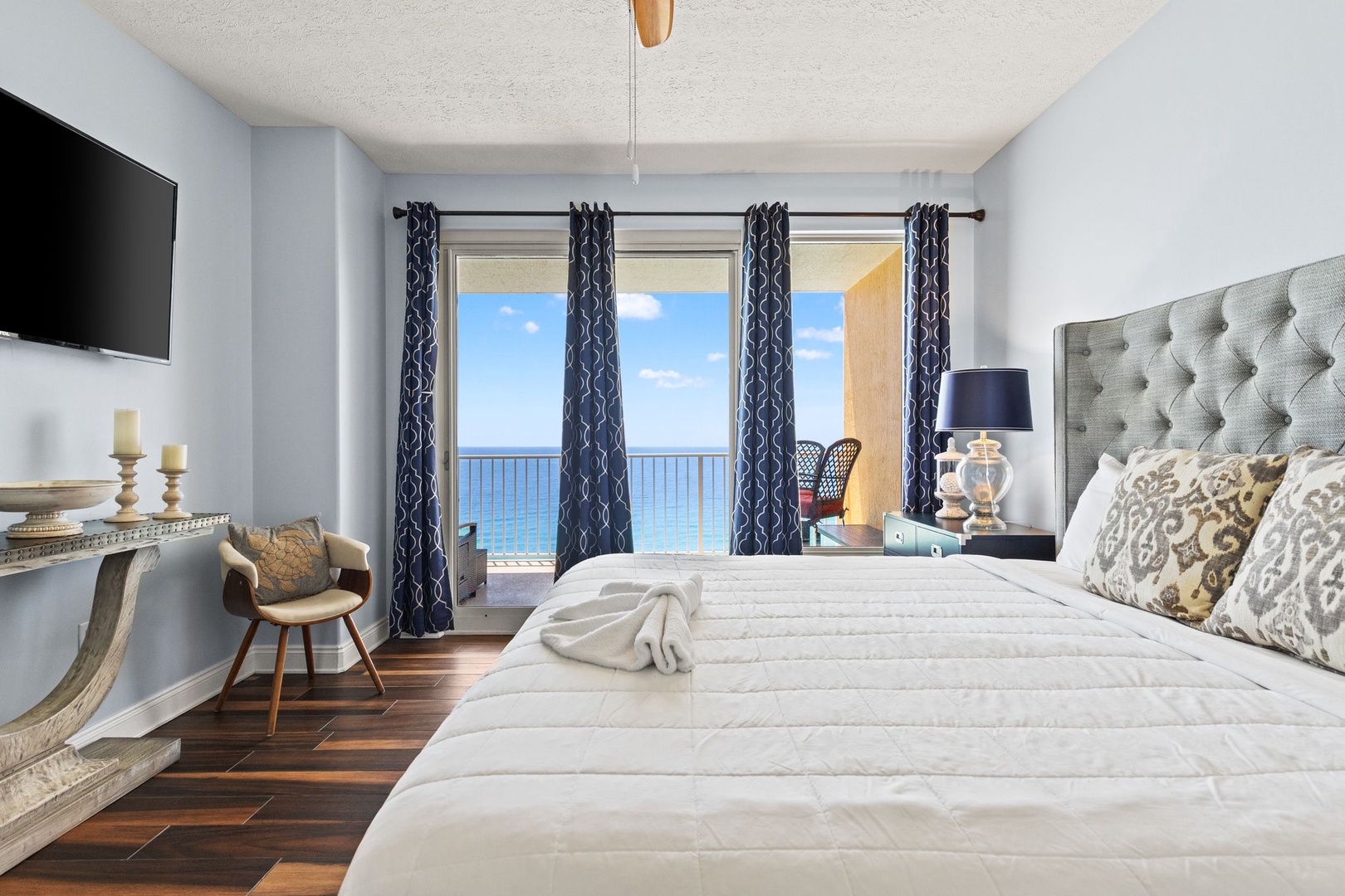 Drift off in this serene bedroom where plush linens and coastal breezes welcome you. Wake to stunning ocean views through your private balcony doors—pure paradise awaits.