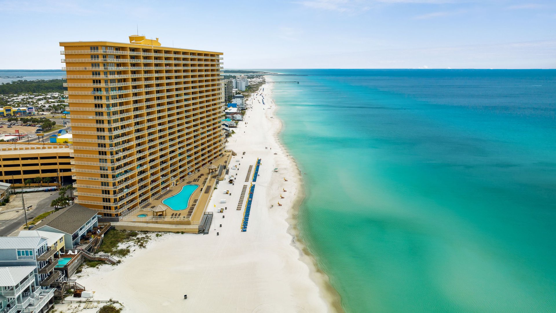 Stunning beachfront resort towers over pristine white sand and crystal-clear turquoise waters in this beautiful coastal destination.