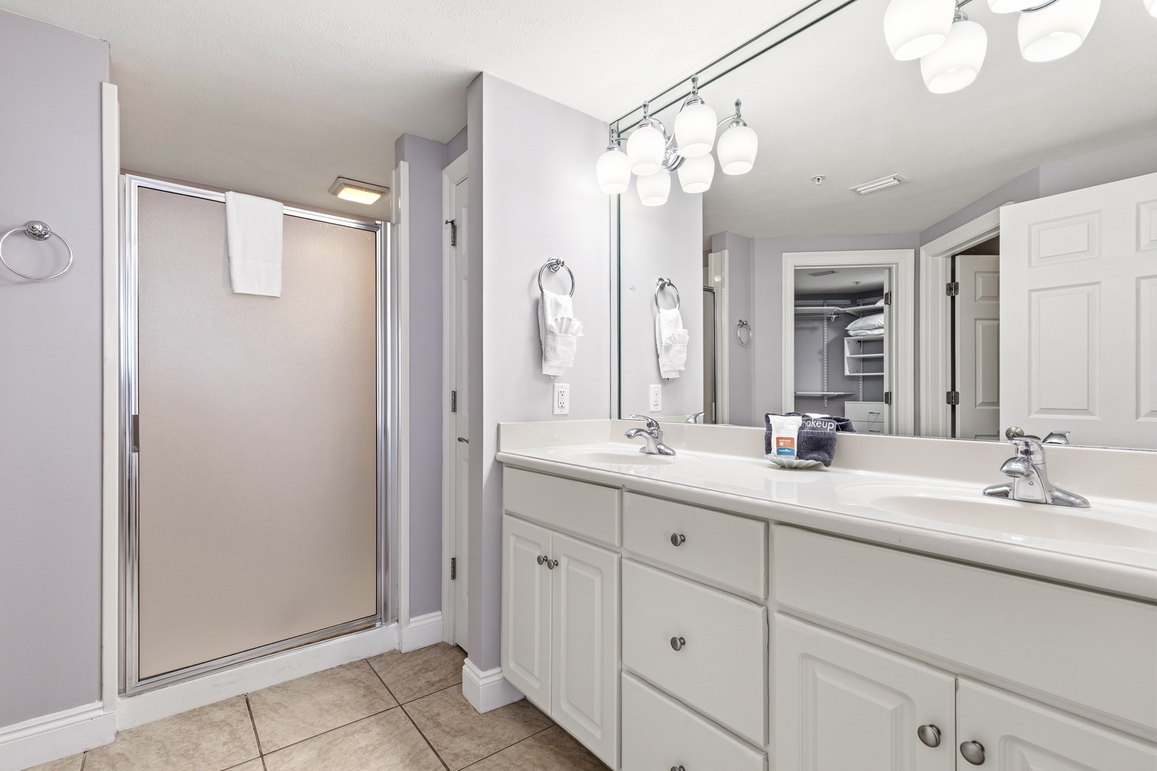 Refresh in your spacious bathroom featuring dual vanities, elegant fixtures, and a roomy shower—perfect for your morning routine.