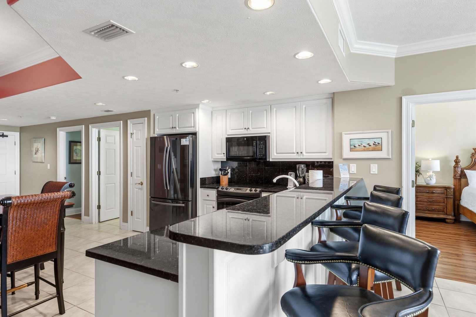 Your fully equipped kitchen features granite countertops, stainless steel appliances, and comfortable bar seating for casual dining.