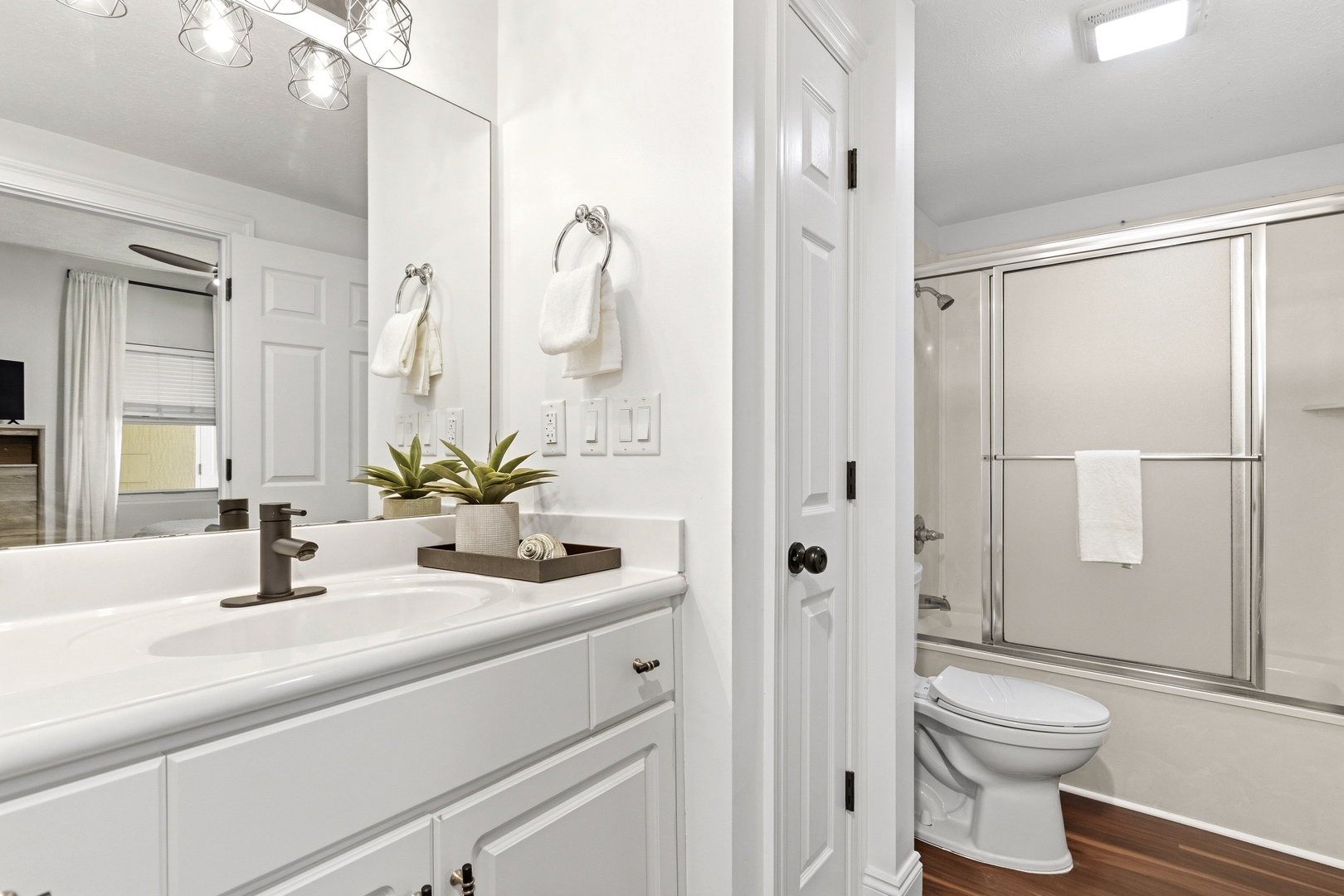Step into your pristine spa-like bathroom with gleaming white finishes, modern fixtures, and fresh towels waiting for you.