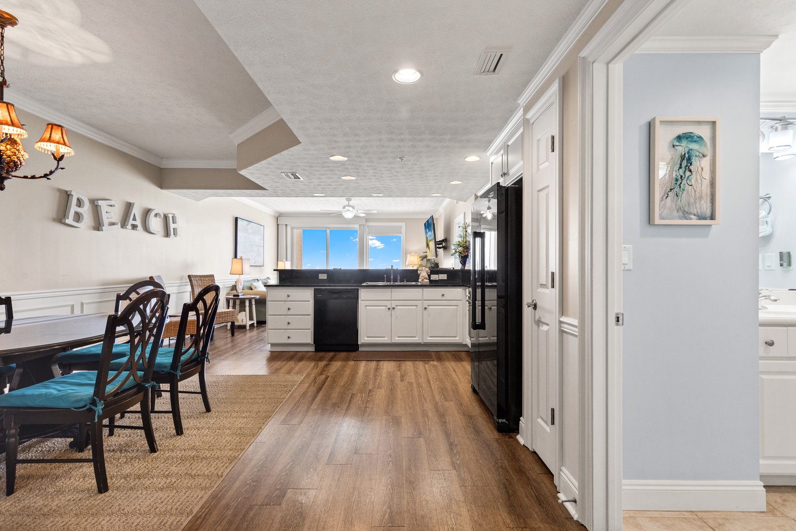 Your coastal-themed kitchen flows beautifully into the dining area, where ocean views and beach-inspired décor create the perfect vacation atmosphere.