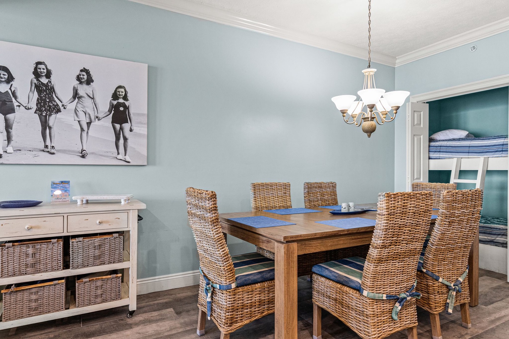 Gather around this coastal-inspired dining area for shared meals and stories, framed by soothing sea-blue tones and beach-themed artwork.