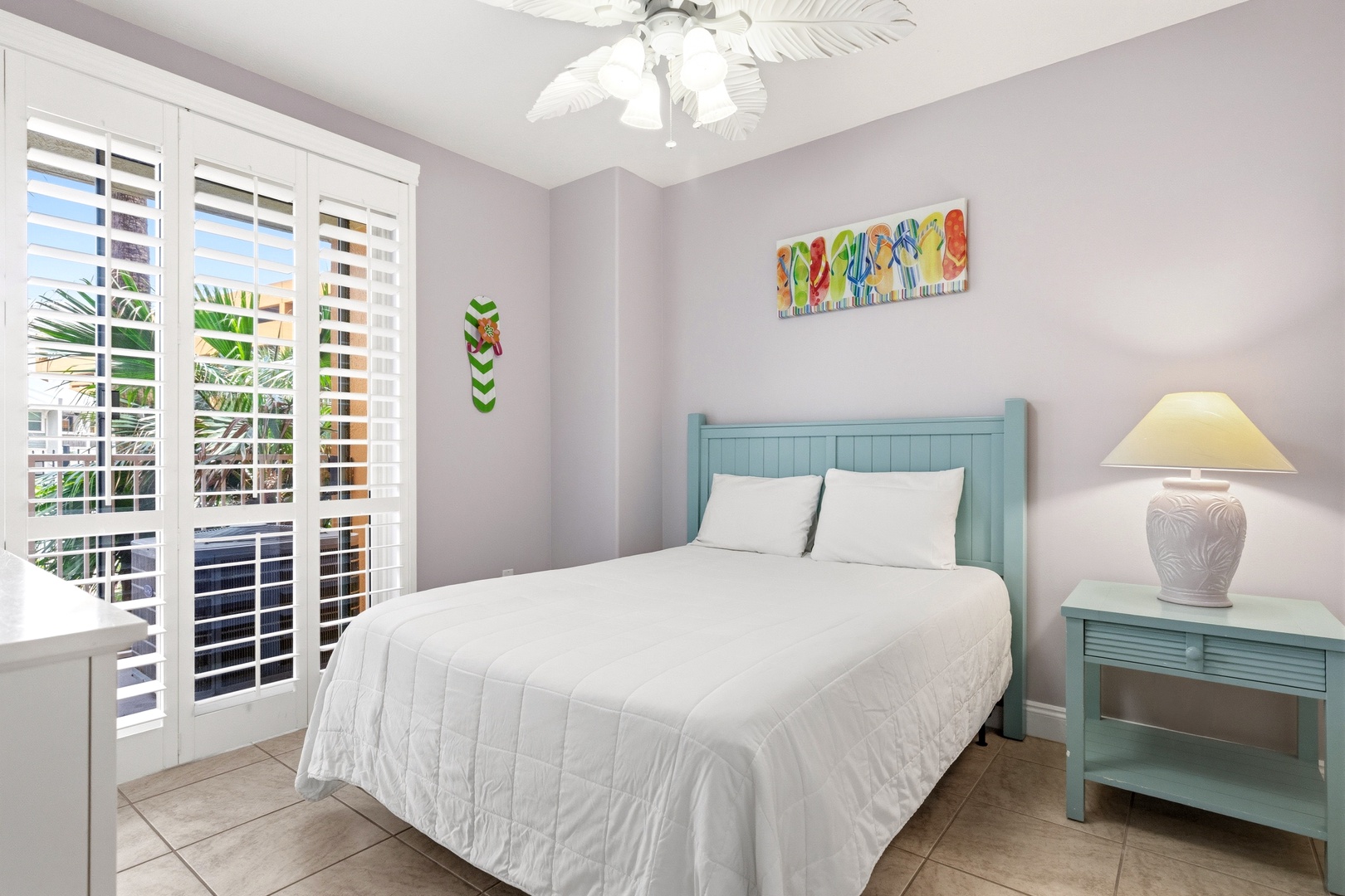 Drift off in your bright, airy bedroom with coastal-inspired decor and cheerful artwork creating a peaceful retreat.