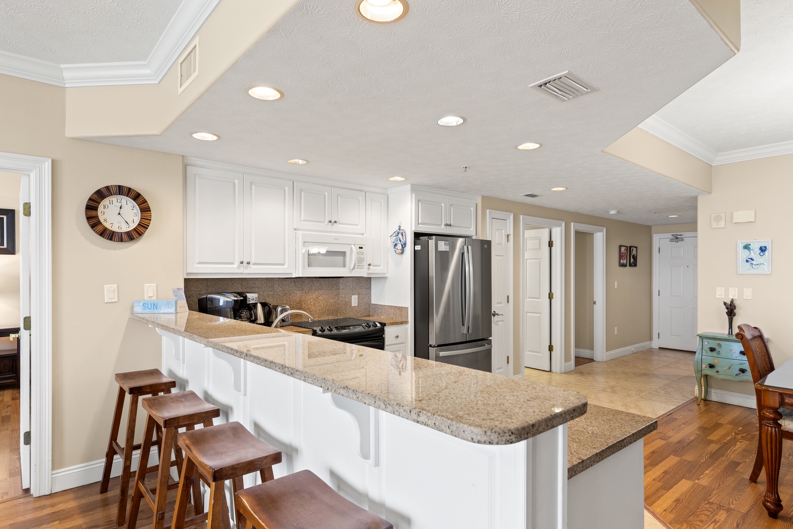 Your fully equipped kitchen features granite counters, stainless appliances, and a breakfast bar with seating—perfect for preparing meals and gathering together in style.