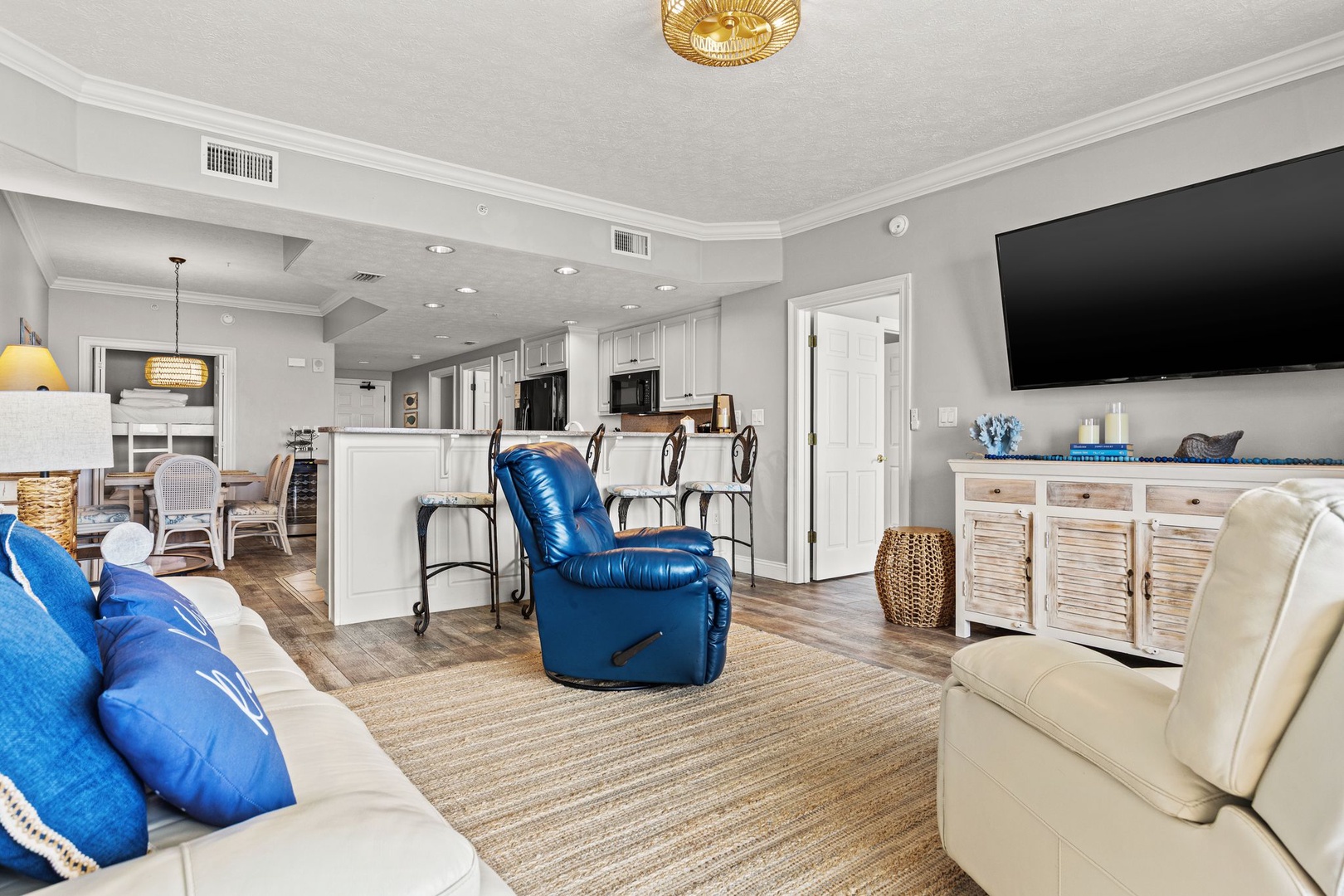 Sink into coastal comfort in this bright, open living space with plush seating, a large TV for movie nights, and a fully equipped kitchen just steps away for easy vacation dining.