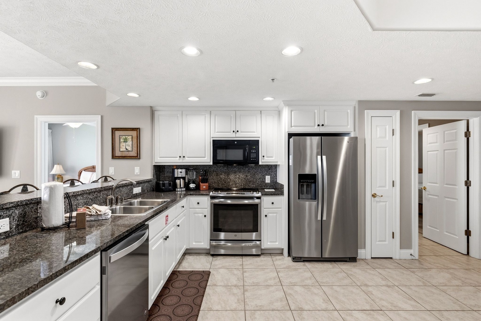 Your spacious kitchen features gleaming granite counters, stainless steel appliances, and crisp white cabinetry—perfect for preparing meals during your stay.