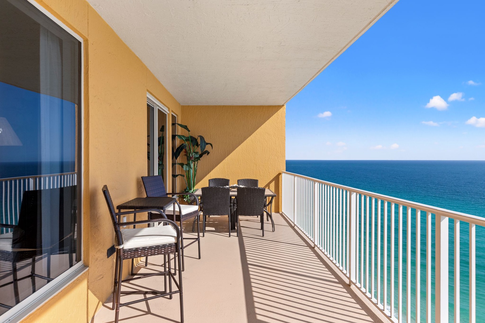 Expansive private balcony offering uninterrupted ocean views, complete with high-top seating for four and coastal breezes—your perfect spot for morning coffee or sunset cocktails overlooking turquoise waters.