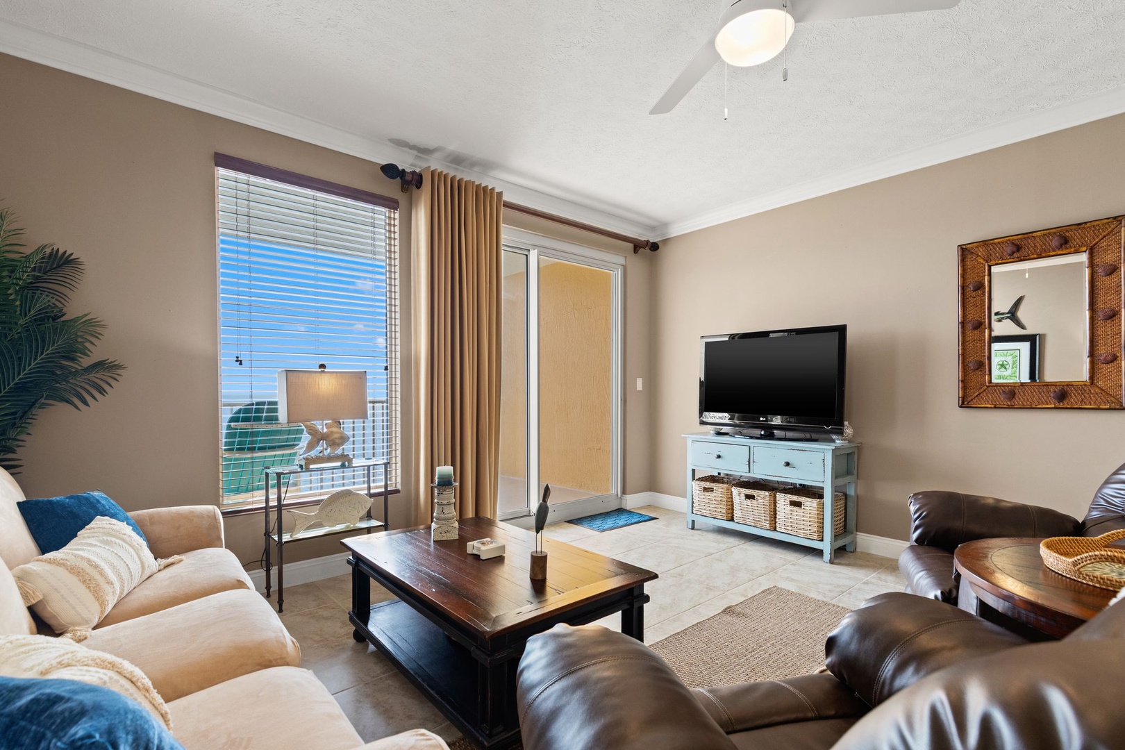 Relax in your bright living area with coastal views, cozy seating, and easy access to your private balcony—perfect for unwinding after a day at the beach.