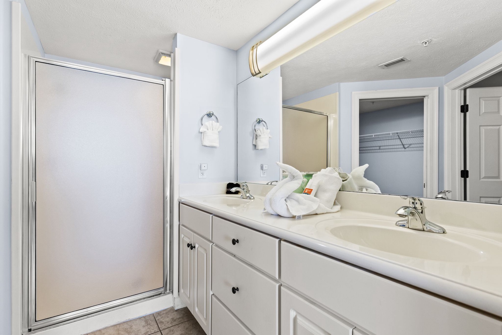 Your private bathroom offers a generous vanity with dual sinks, plenty of storage, and a spacious walk-in shower—all bathed in natural light for a fresh, airy feel.