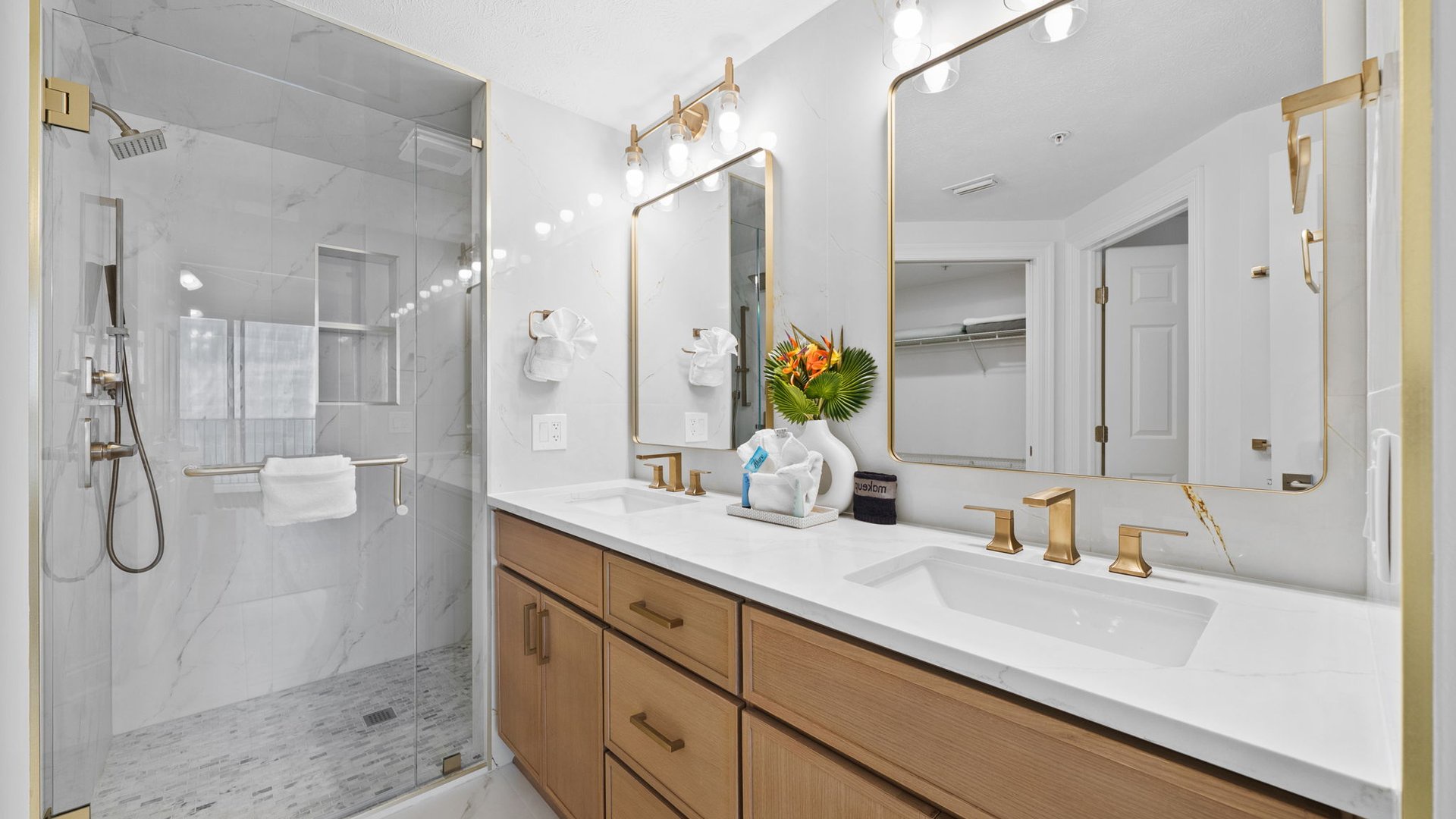 Step into your spa-like bathroom with dual vanities, marble finishes, and a luxurious glass-enclosed shower for ultimate relaxation.