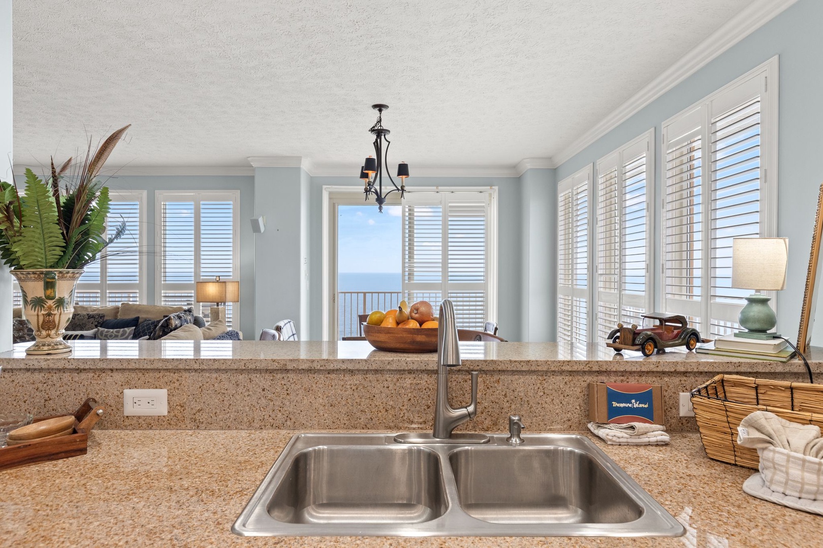 Imagine preparing meals here with stunning ocean views as your backdrop, where granite counters, a double sink, and breezy coastal light make every moment feel effortless and serene.