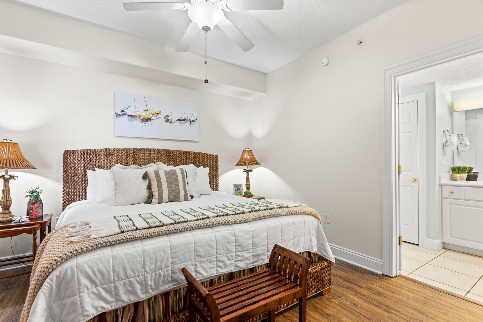 Sink into your coastal-inspired bedroom with a plush woven headboard, crisp linens, and soothing nautical art that invites restful nights after sunny beach days.