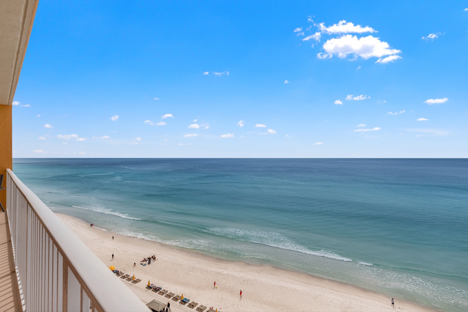 Stunning ocean panorama stretches endlessly from this high-rise balcony, with pristine beach below.