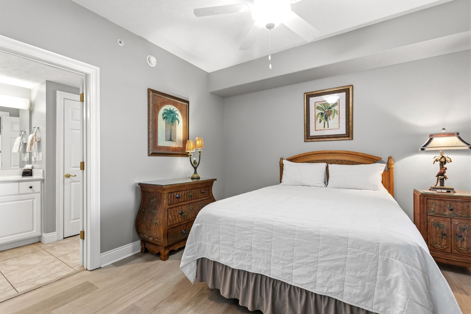 Sink into the plush comfort of your private bedroom retreat, where tropical artwork and elegant furnishings create a serene escape.