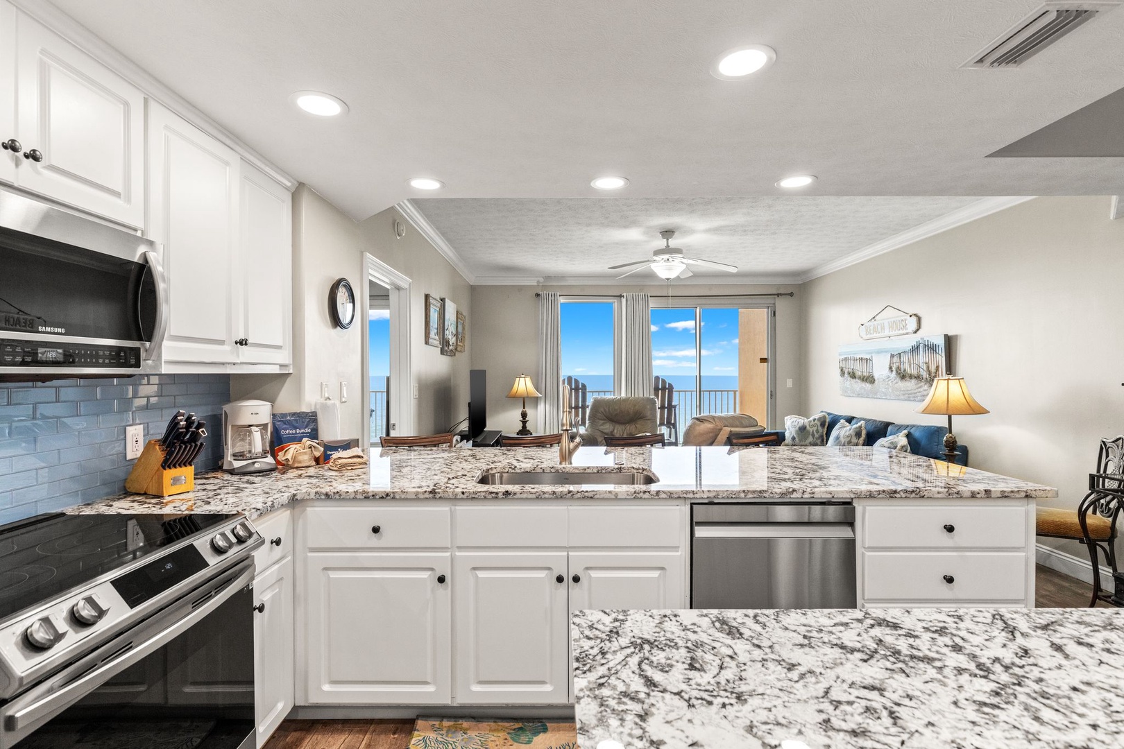 Your fully equipped kitchen overlooks the living room and opens to a bright balcony with stunning ocean views, creating a perfect flow for beach living.