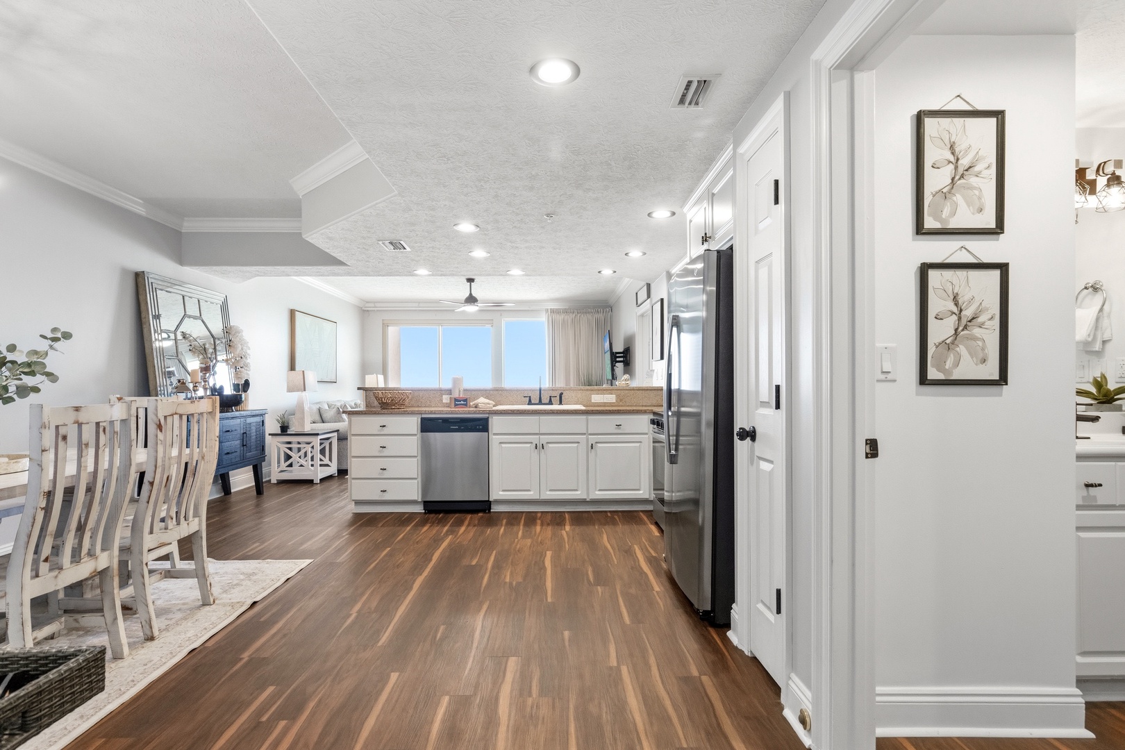 Step into your spacious kitchen where gleaming white cabinets and modern appliances await your culinary adventures, with ocean views to inspire every meal.