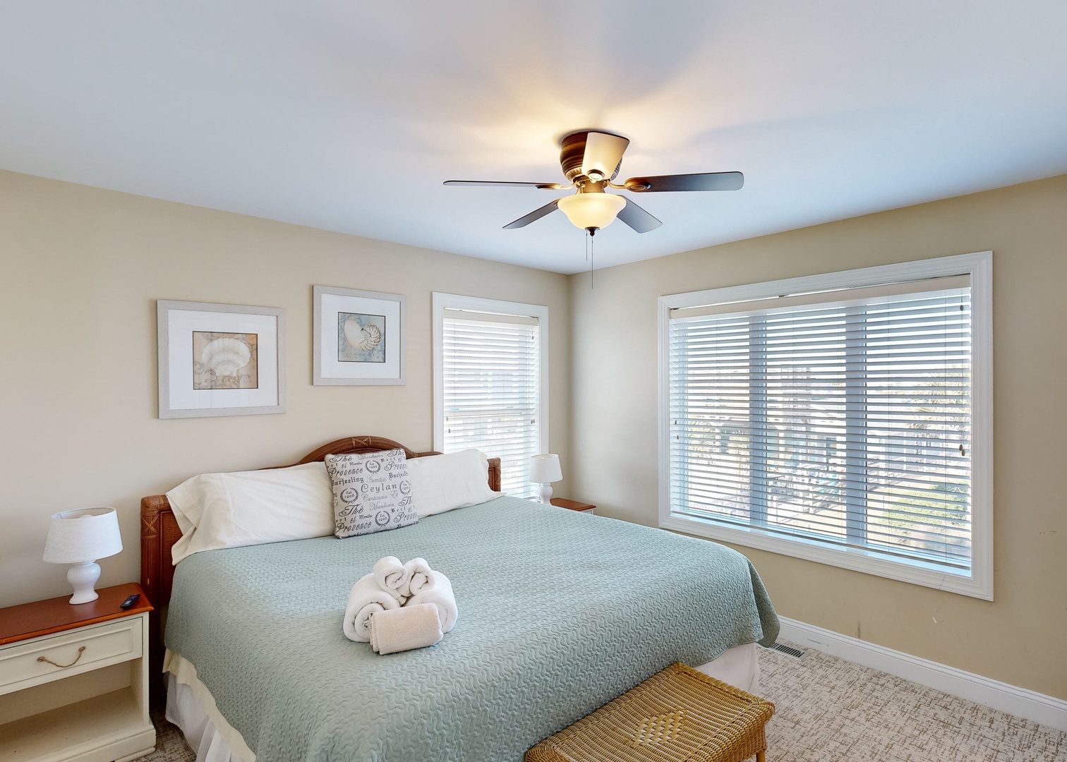 Sink into your coastal retreat with this serene bedroom featuring soft linens, coastal decor, and abundant natural light. Fresh towels await your arrival.