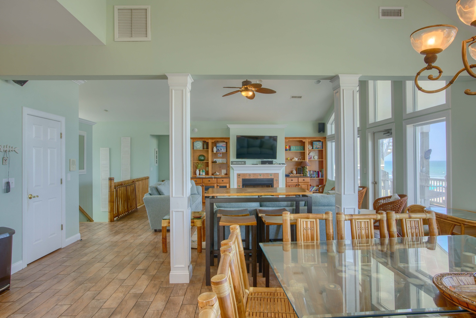 Your spacious open-concept retreat flows seamlessly from dining to living areas, with coastal light pouring through floor-to-ceiling windows that frame stunning ocean views beyond your private balcony.