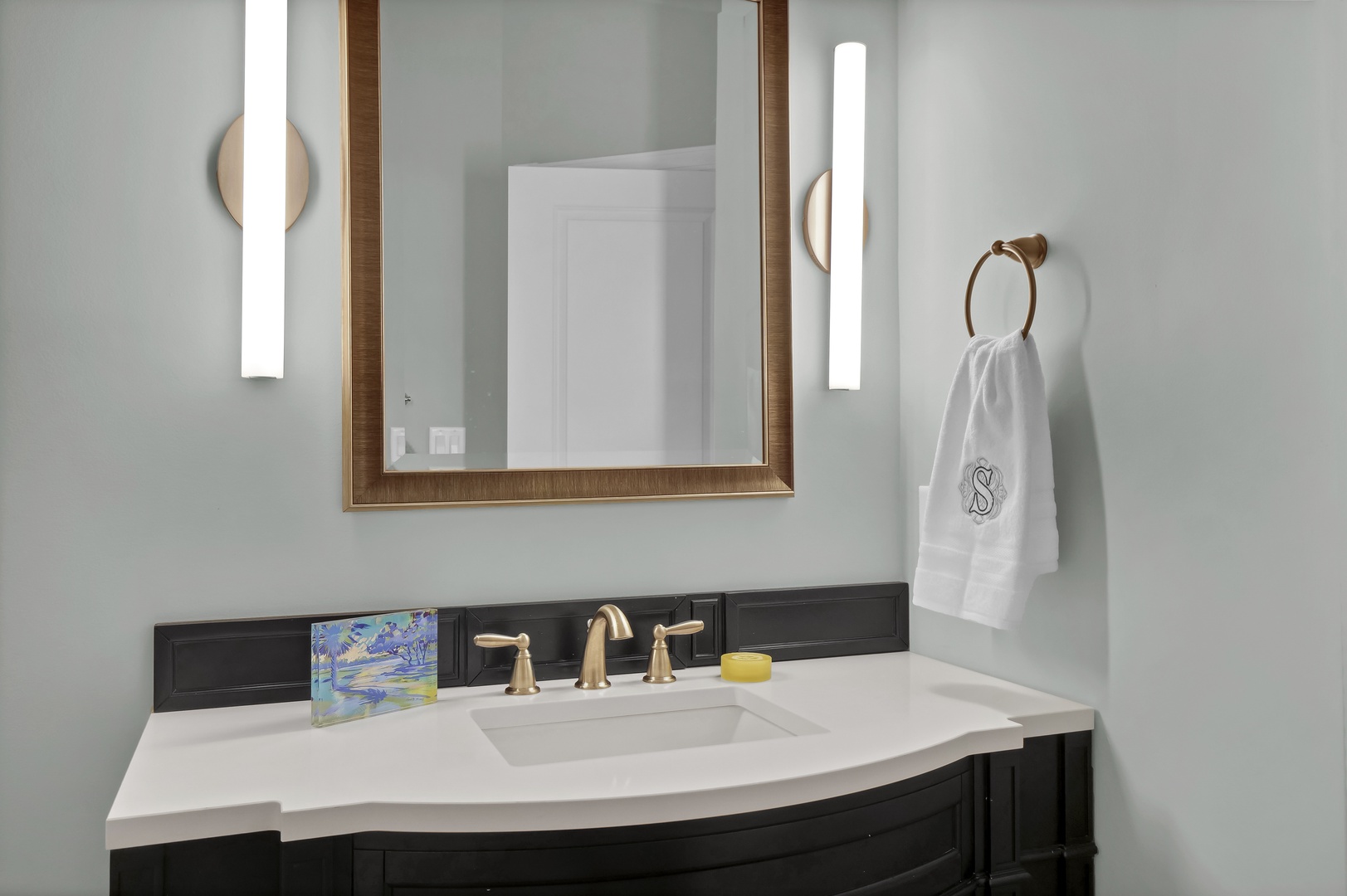 Elegant bathroom vanity with modern lighting and fresh linens ready for your arrival.