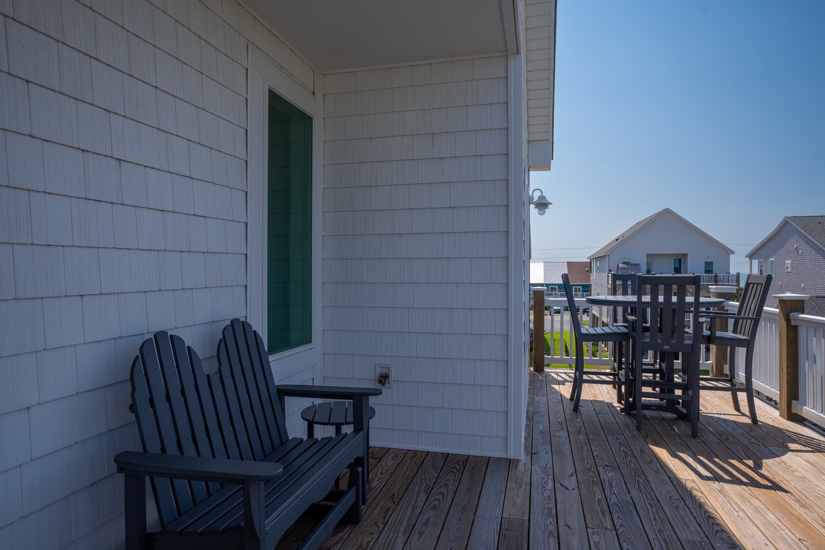 Your private deck awaits with Adirondack seating and high-top dining, perfect for morning coffee or sunset cocktails with views of the surrounding coastal neighborhood.