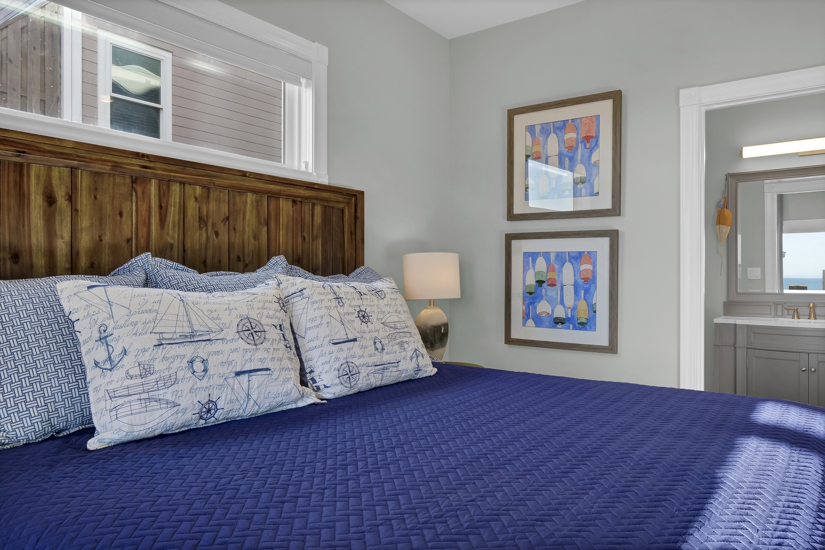Your coastal retreat awaits with a plush king bed, warm wooden accents, and nautical touches that bring the sea indoors. Soft natural light and a serene color palette create the perfect escape.