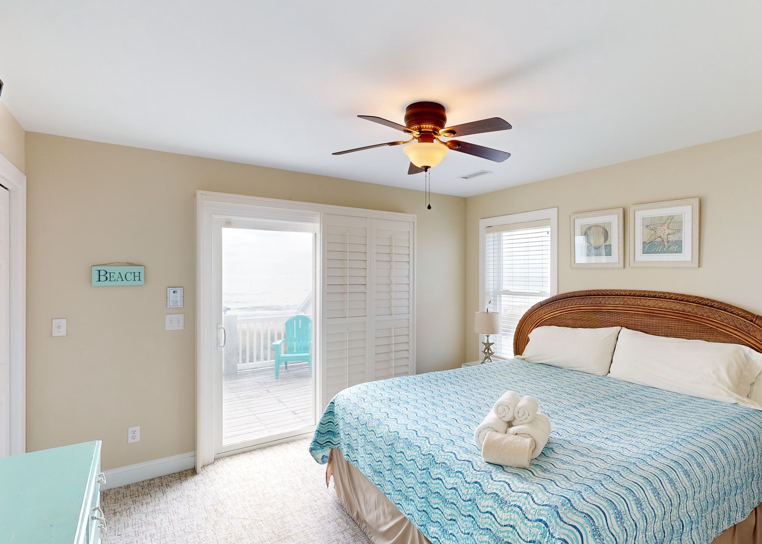 Wake up to gentle breezes and sunlight streaming through your private balcony doors, where fluffy towels await on a bed dressed in soothing coastal blue tones.