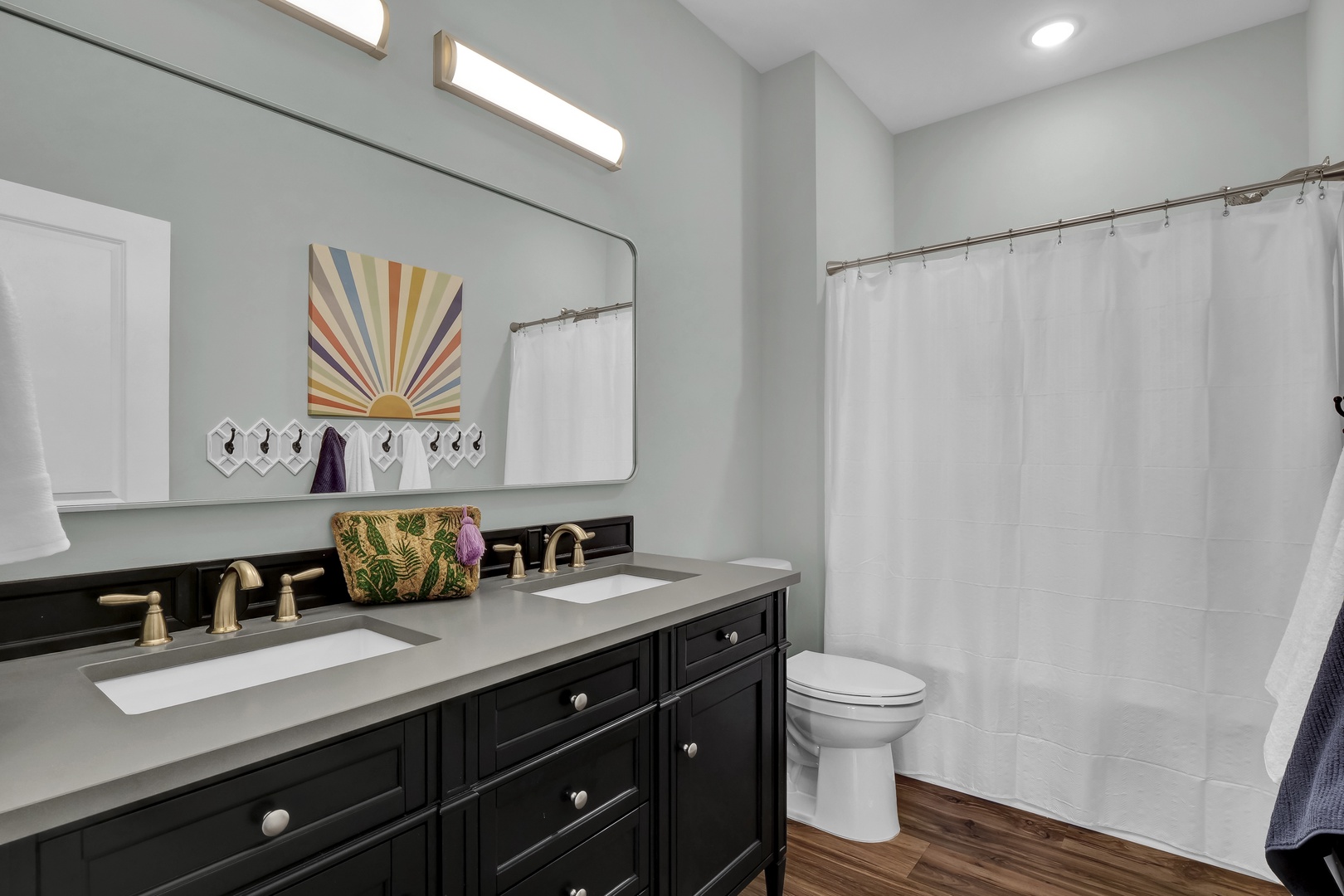 Step into your bright, spa-inspired bathroom, where a spacious double vanity, crisp white shower curtain, and thoughtful touches like fresh towels and stylish décor await to refresh you after a day of adventure.