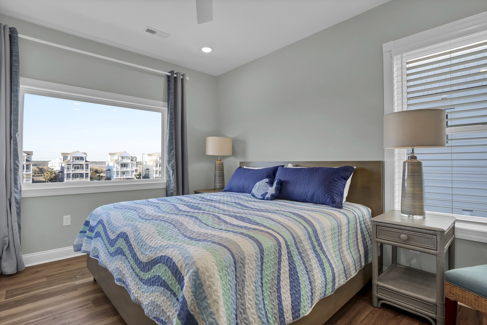 Drift off in this serene bedroom with coastal-inspired linens and soft natural light filtering through the blinds, creating your perfect beach town retreat.