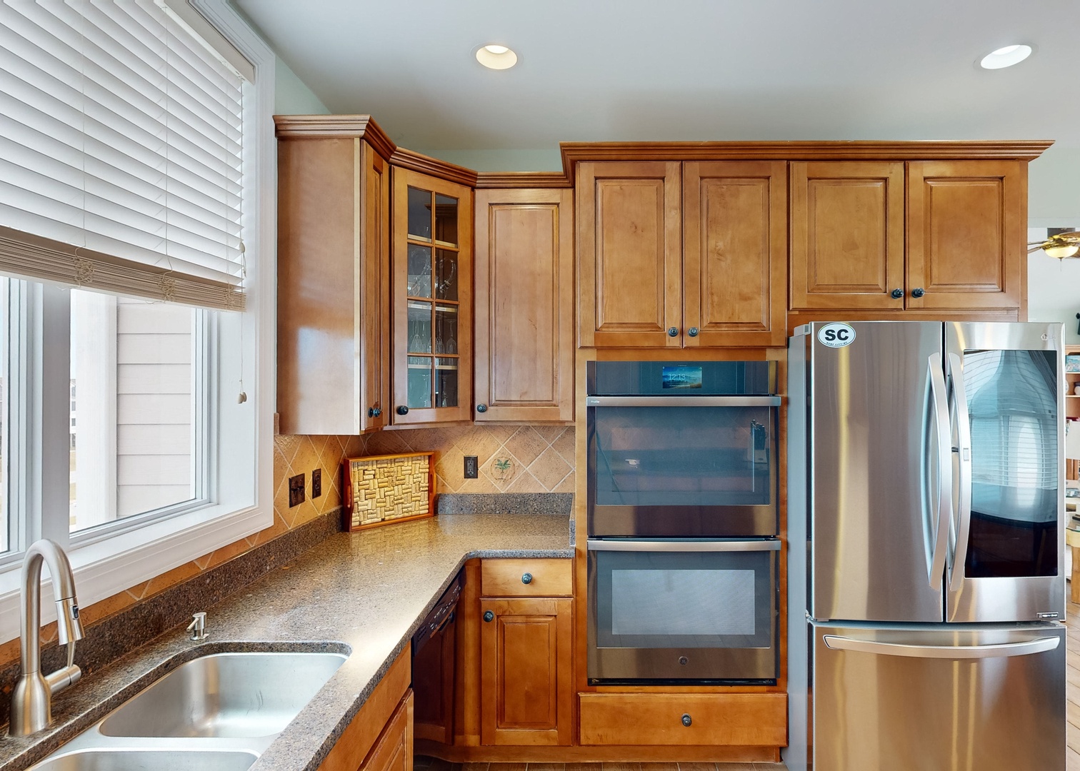 Cook up your favorite meals in this inviting, fully equipped kitchen with gleaming granite counters, warm wood cabinetry, and modern stainless appliances—everything you need at your fingertips.