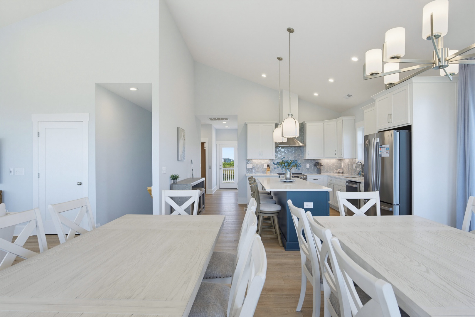 Gather around this bright, open kitchen and dining space with coastal-inspired blue island, ample seating, and modern appliances—perfect for preparing meals and sharing stories with your group.