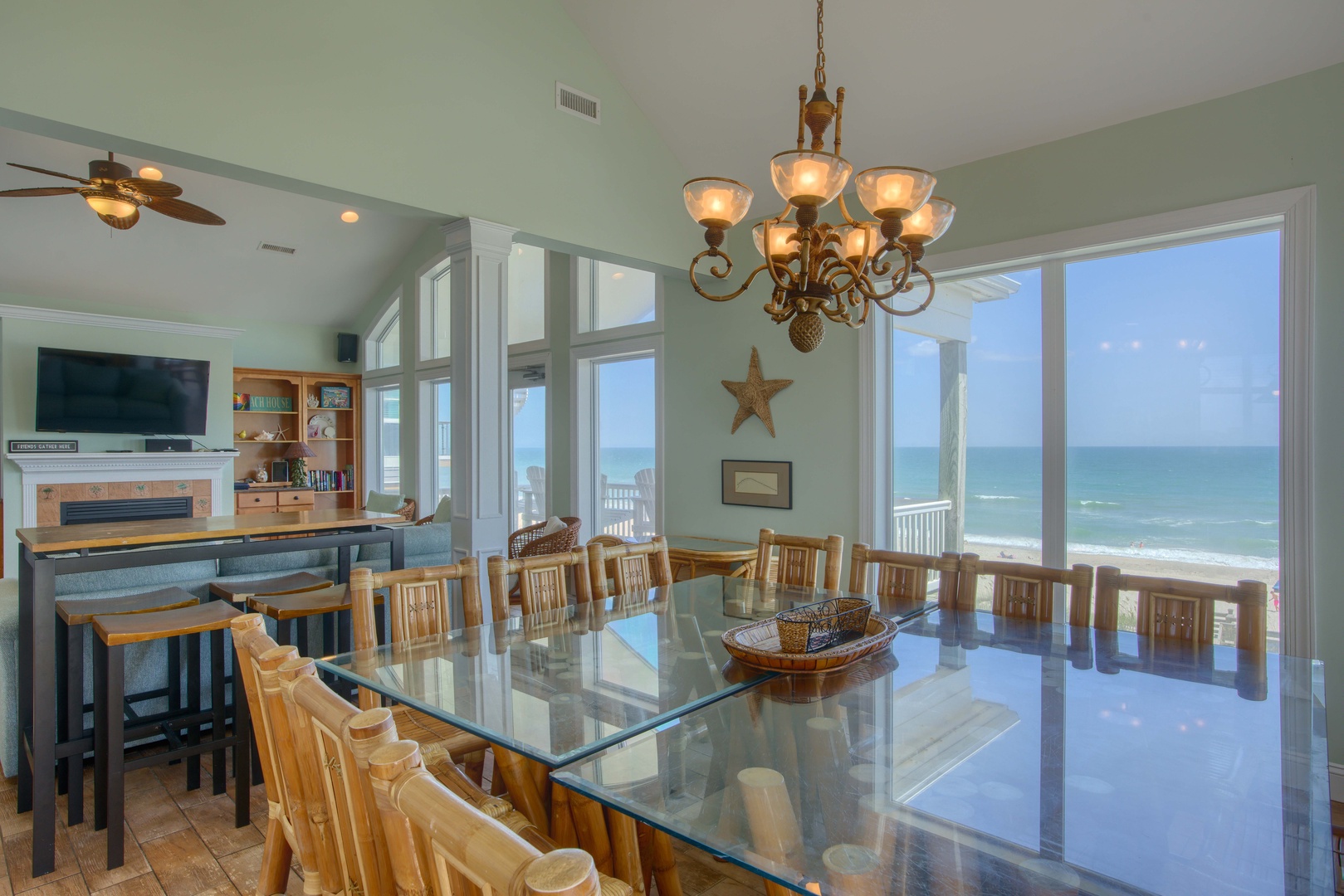 Gather around this expansive glass-topped table where the ocean stretches out before you through floor-to-ceiling windows, creating an unforgettable backdrop for your meals and conversations.