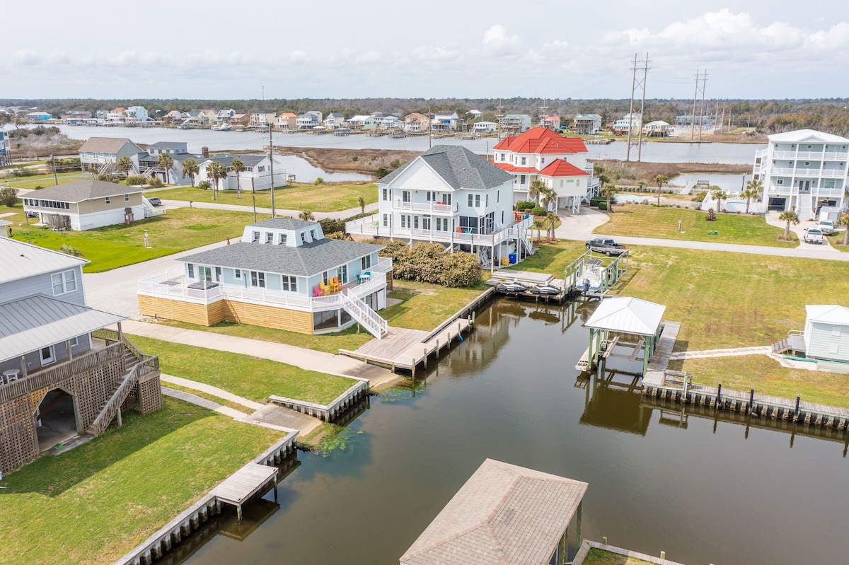 A waterfront property with multiple houses, docks, and a canal.