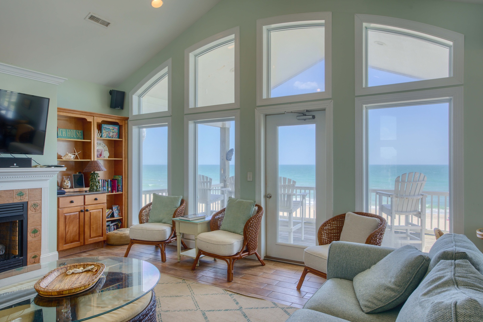 Your beachfront retreat awaits with stunning ocean views through floor-to-ceiling windows. Sink into coastal-themed seating and step onto your private balcony to feel the sea breeze.