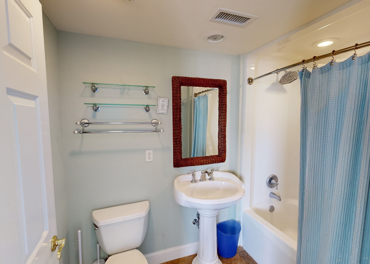 Step into your freshly updated bathroom with a pedestal sink, spacious tub-shower combo, and thoughtful touches like glass shelves and extra towel bars to keep everything within reach.