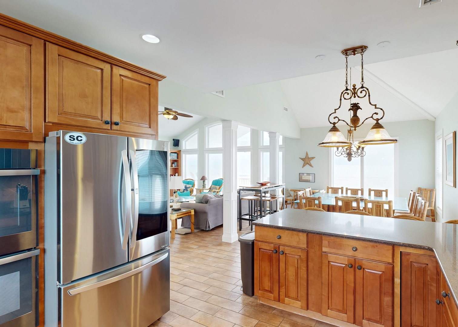 Step into your spacious open-concept kitchen and gathering area, where vaulted ceilings and abundant natural light create a warm, welcoming atmosphere for cooking and connecting with loved ones.