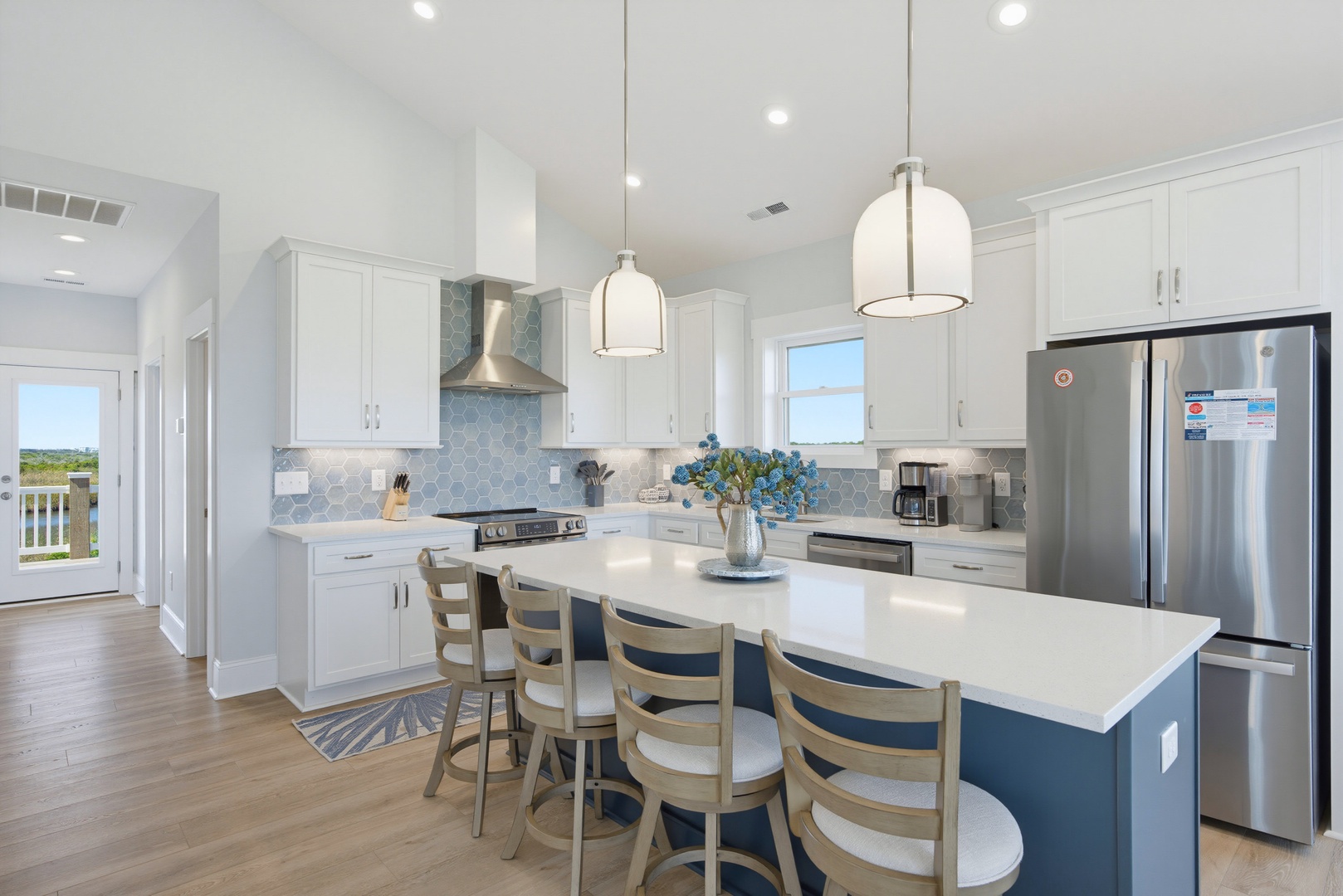 Step into your fully-equipped kitchen with a spacious island for gathering, modern appliances, and a coastal color palette that sets the tone for relaxed evenings at home.
