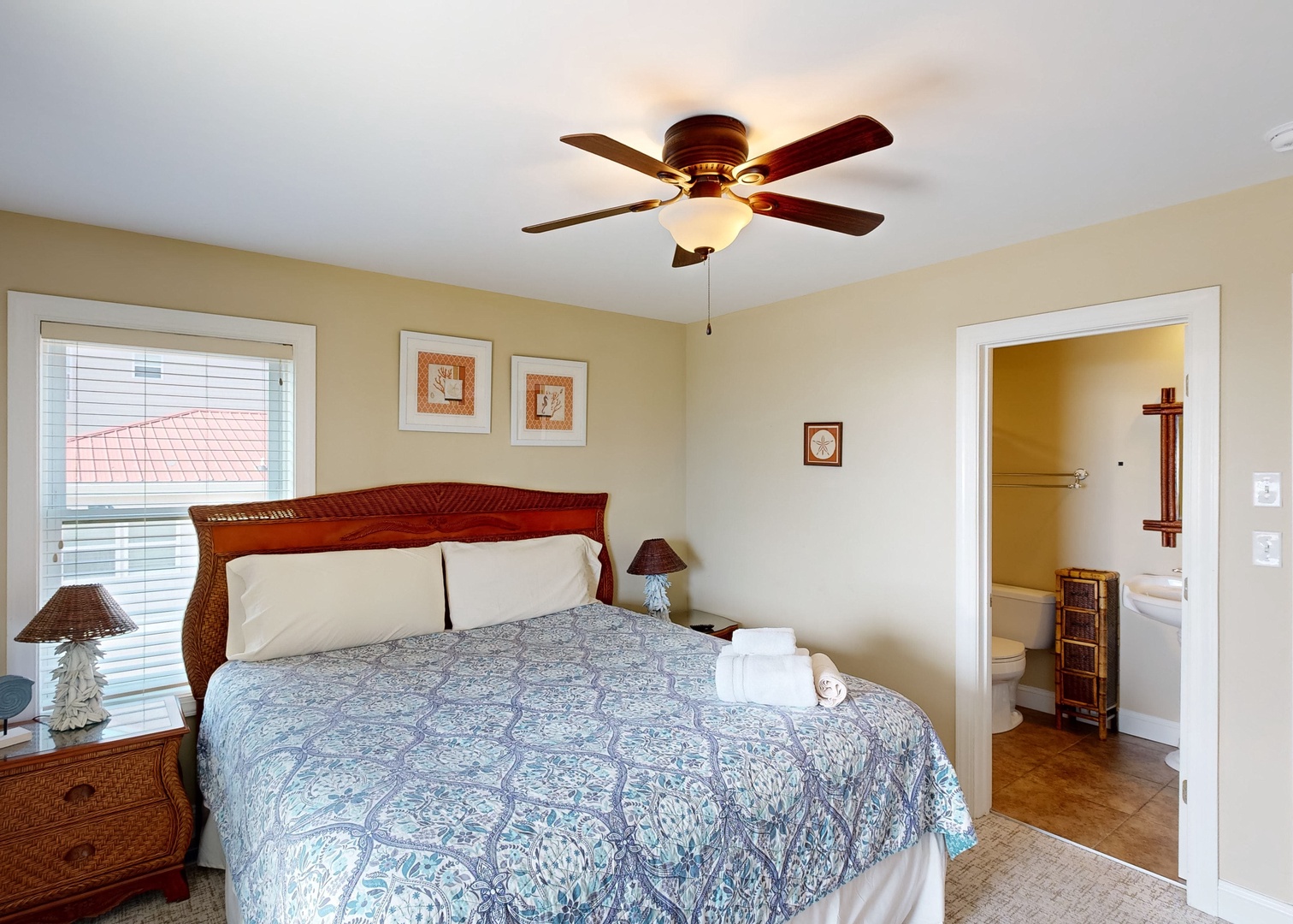 Rest easy in your cozy bedroom, complete with a plush bed, ceiling fan, and natural light streaming through the window to help you wake up refreshed.