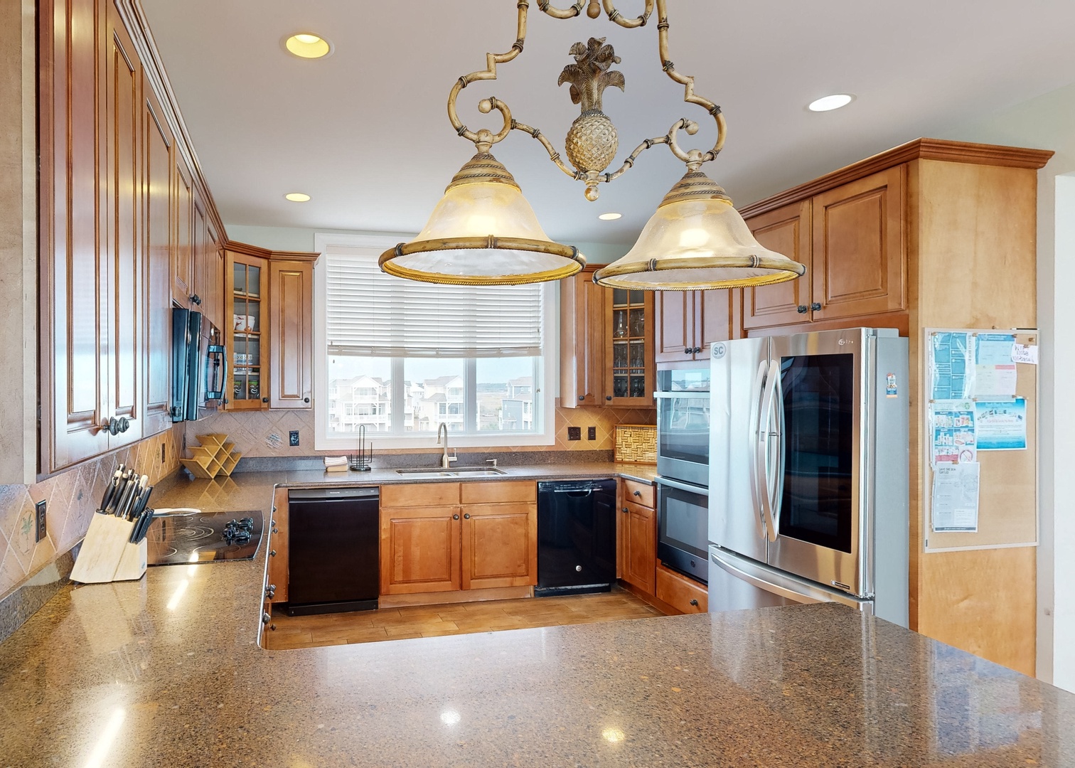 Prepare delicious meals in your spacious, fully equipped kitchen with gleaming granite countertops, stainless steel appliances, and elegant lighting creating the perfect culinary atmosphere.