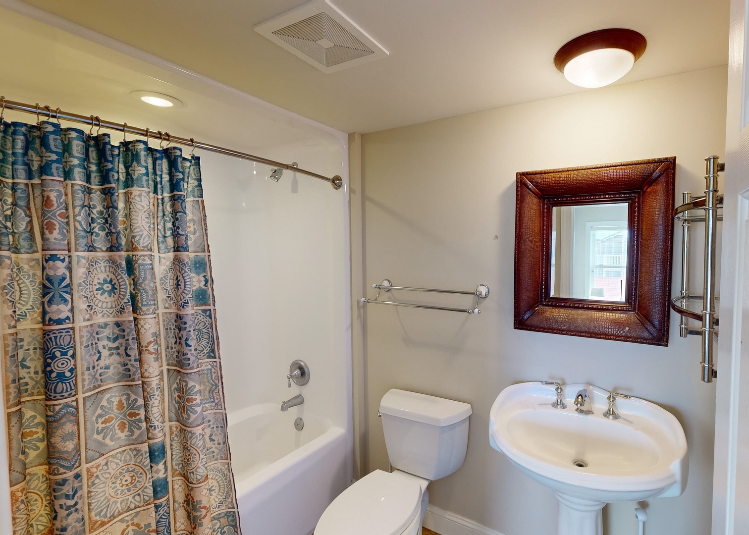 Your private bathroom features a refreshing shower-tub combo, pedestal sink, and warm coastal touches that make freshening up feel like a mini retreat.
