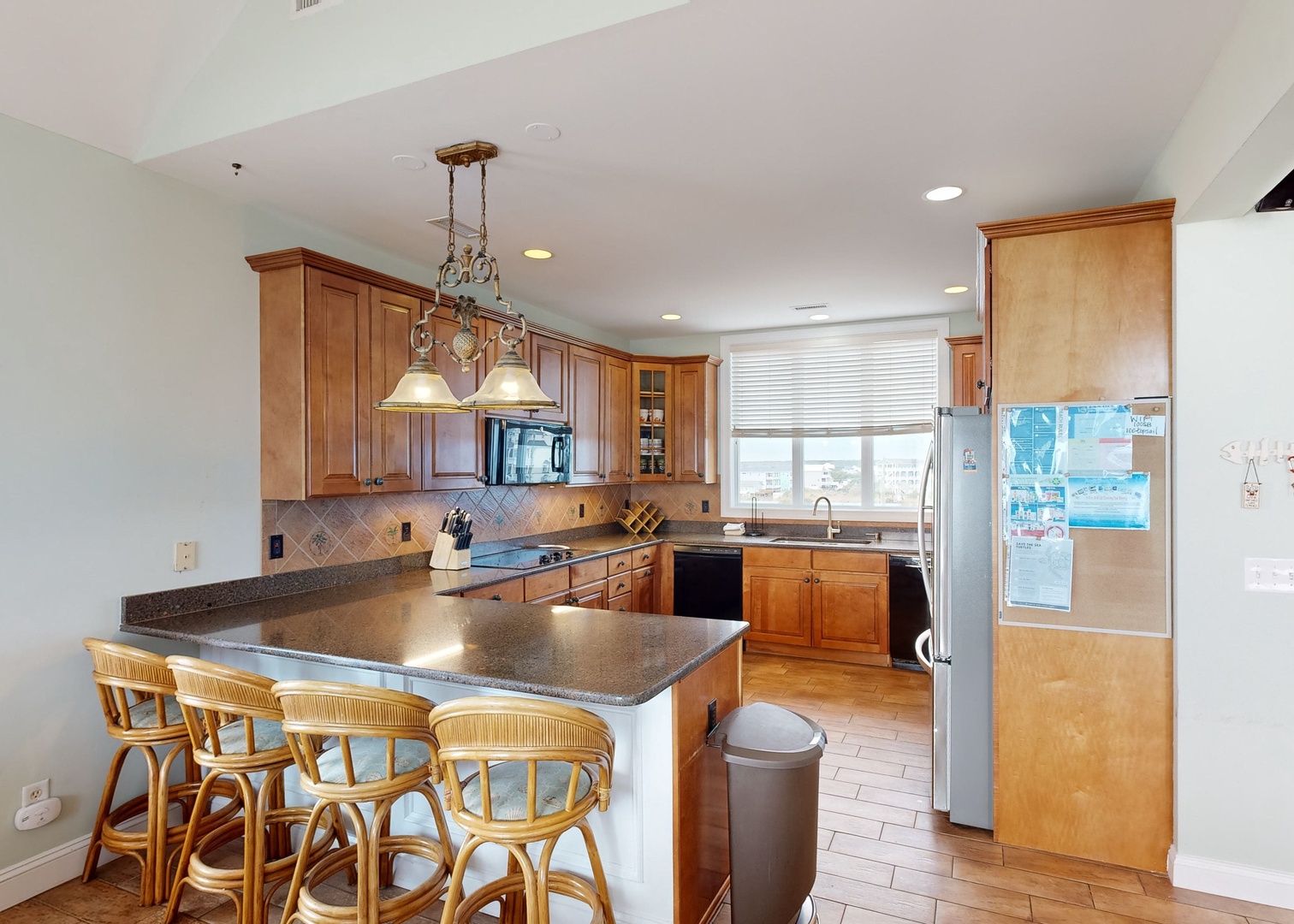 Your fully equipped kitchen features warm wood cabinetry, granite countertops, and a breakfast bar where you can enjoy morning coffee while planning the day's adventures.