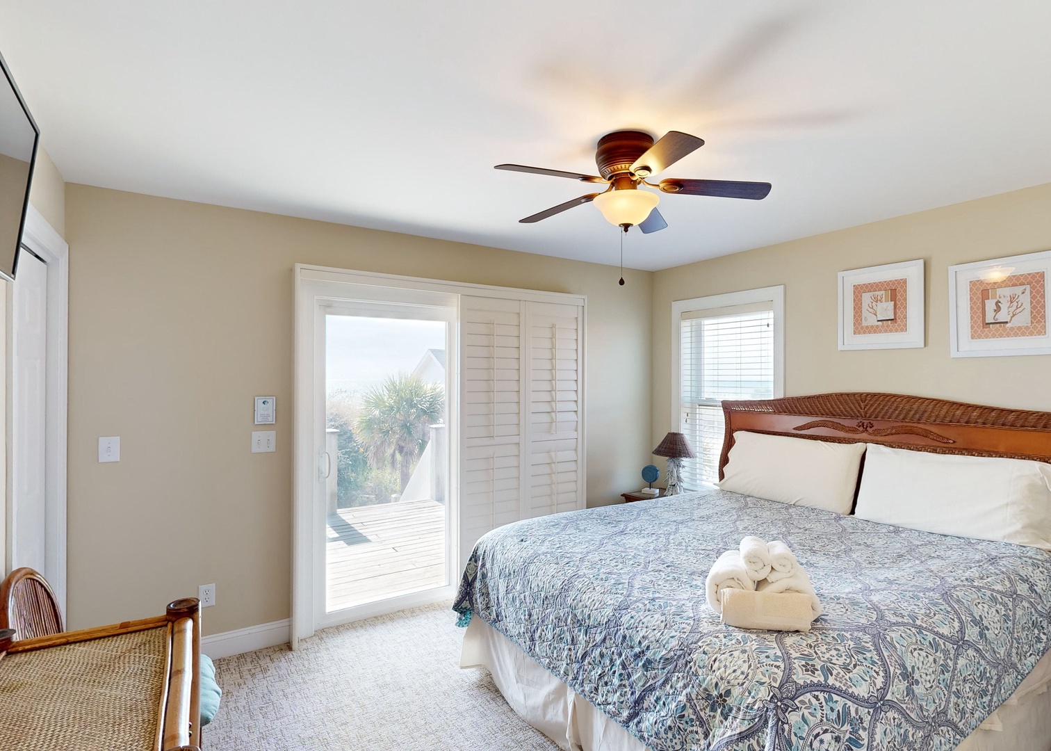 Step into your serene coastal retreat, where soft neutral tones and a beautifully appointed bed promise restful nights. French doors open to your private deck, inviting gentle breezes and natural light into your peaceful sanctuary.
